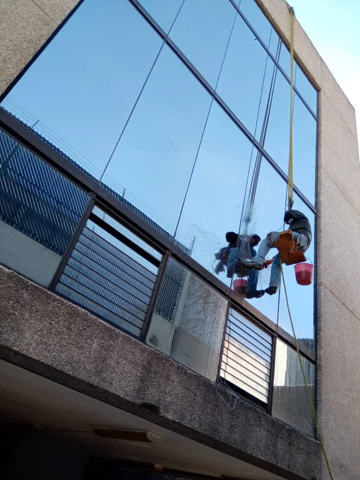 Limpieza de fachada de cristal en altura